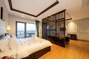 Um quarto espaçoso com uma cama grande, vista para o exterior e um painel com padrões elaborados.