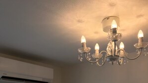 Un dormitorio con candelabro, aire acondicionado, cortinas y adhesivos decorativos de mariposas.
