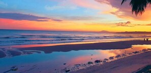 A beach at sunset with calm waves and a clear sky. - iHome Mui Ne - Hostel (Mui Ne)