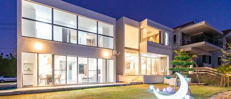 Vista frontal de la propiedad por la tarde o noche