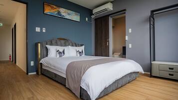 Un dormitorio moderno con una cama grande, un armario y un equipo de aire acondicionado.
