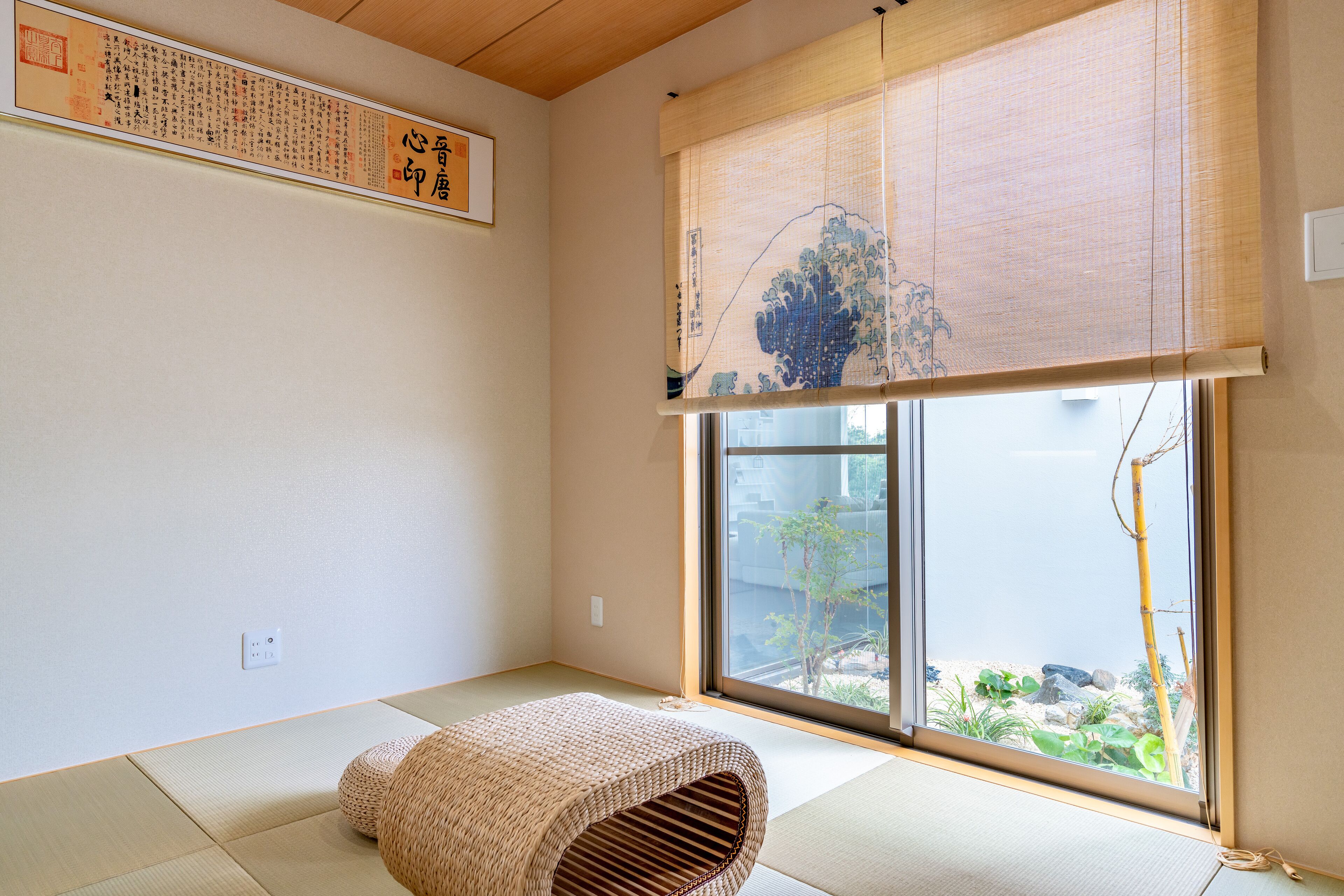A traditional Japanese room with tatami flooring, a shoji screen, and a view of a garden through a sliding door.