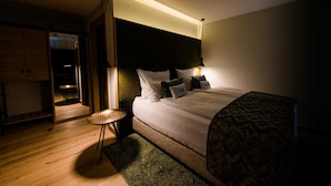 Un dormitorio moderno con una cama grande, una mesita de noche y un armario.