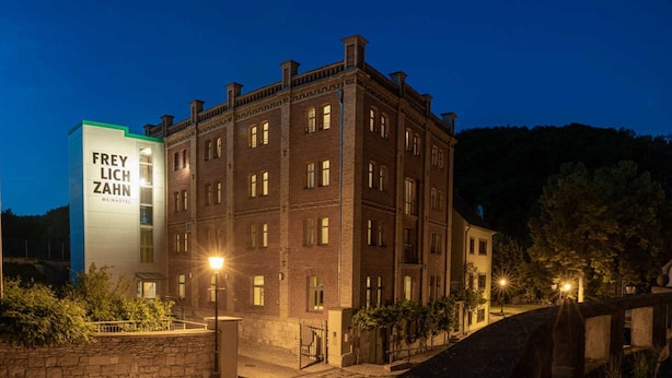 Un edificio histórico con una extensión moderna identificada como "FREY LICH ZAHN WEINHOTEL".