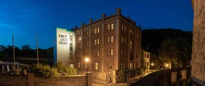 En historisk bygning med en moderne tilbygning, hvor der står "FREY LICH ZAHN WEINHOTEL".