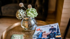 Una revista sobre una bandeja con un florero y una pila de tarjetas.