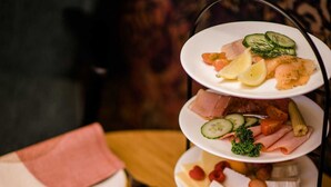 Una presentación de comida en tres niveles que incluye pepinos en rodajas, tomates y queso.