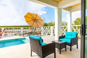 Een buitenzwembad, ligstoelen bij het zwembad