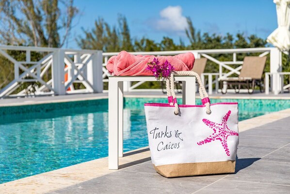 Een buitenzwembad, ligstoelen bij het zwembad