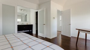 A bedroom with a bed, a dresser, a mirror, and a door leading to another room. - The Minimalism near FC Q2✌🏻5 mins to Domain ATX ❤️ (Austin)