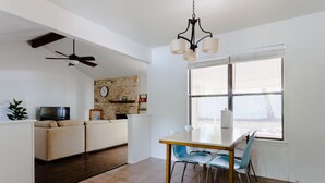 A modern living room with a dining area, a TV, a fireplace, and a large window. - The Minimalism near FC Q2✌🏻5 mins to Domain ATX ❤️ (Austin)