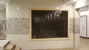 A hotel lobby with a large window, tiled walls, and a staircase leading to an upper floor. - Ema Ozturk Thermal Hotel (Afyonkarahisar)
