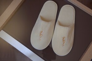 A pair of slippers with a logo on a wooden surface.