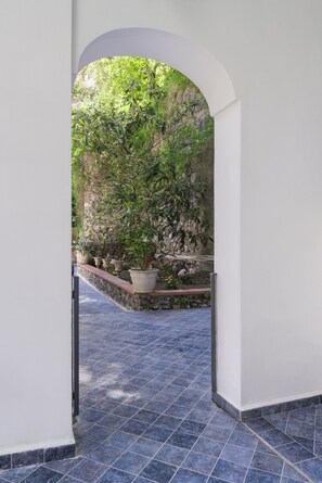An indoor corridor with a tiled floor and a stone wall. - Villa Carrino (Positano)