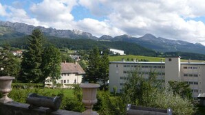 A view of a mountainous landscape with a building in the foreground and a clear sky.