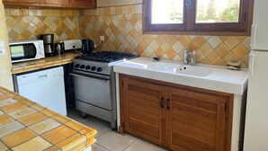 A kitchen with wooden cabinets, a microwave, a stove, a dishwasher, and a sink.