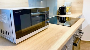 Una cocina moderna con un microondas Sharp, una cafetera y una encimera elegante.