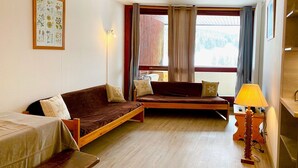 Una habitación acogedora con sofá, cama, escritorio y lámpara.