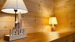 Una pared de madera con una mesa de madera y dos lámparas.