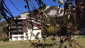 A multi-story building with a flat roof, surrounded by a grassy area and trees. - Studio at the foot of slopes with balcony Corrençon-en-Vercors (Corrençon-en-Vercors)