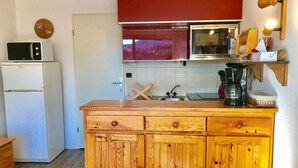 A kitchen with a wooden countertop, a white refrigerator, a microwave, a coffee maker, and a clock on the wall. - Studio cabin with balcony, mountain view near village center (Villard-de-Lans)