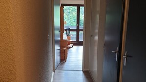 A hallway with a wooden floor leading to a room with a large window. - 32m² Studio at Ski Slopes Foot in Corrençon (Corrençon-en-Vercors)