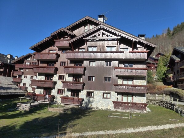 A multi-story hotel with wooden balconies and stone facade.