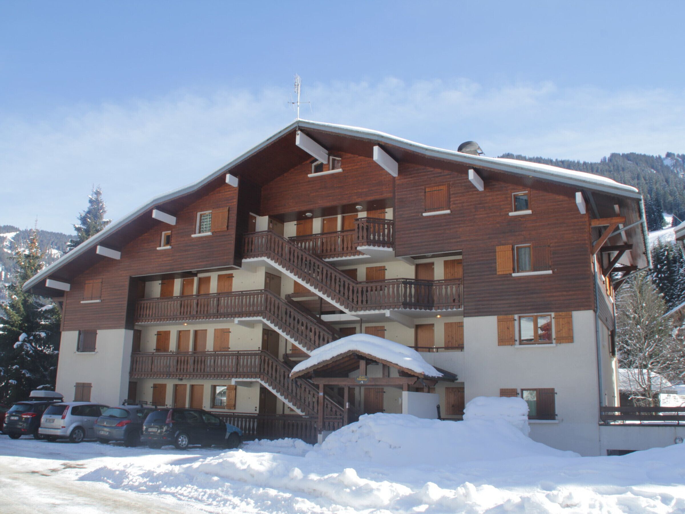 A multi-story wooden building with balconies and a staircase.