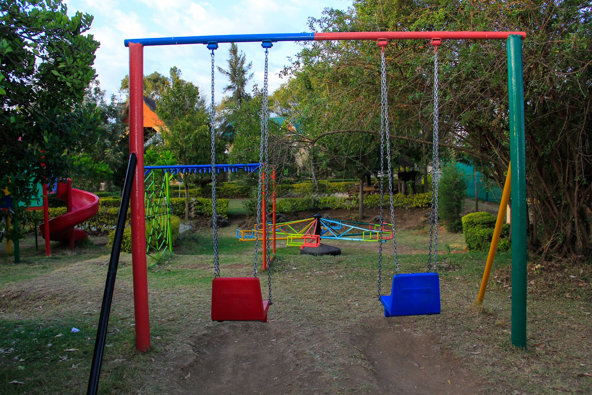 A playground with swings, a slide, and a climbing structure.
