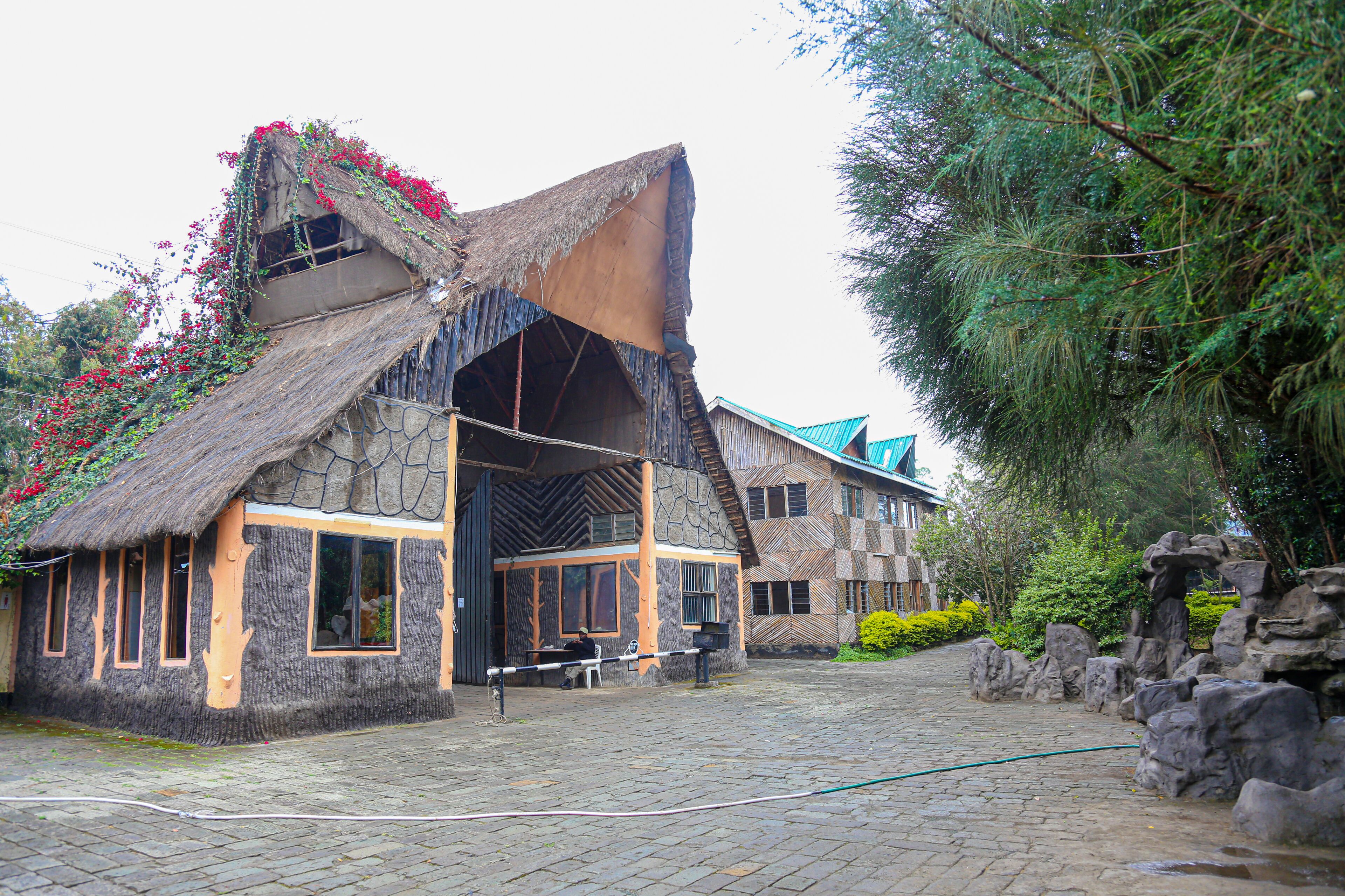 A rustic building with a thatched roof, stone walls, and a large entrance.
