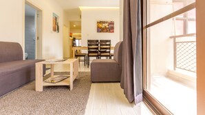 Ein Wohnzimmer mit einer Couch, einem Couchtisch und einem Essbereich mit Stühlen und einem Tisch.