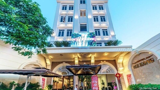 Een hotel met een statig entree, een groot digitaal scherm en traditionele Chinese decoraties.