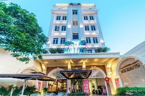A hotel with a grand entrance, a large digital display, and traditional Chinese decorations.