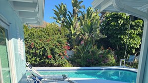 Ein Poolbereich mit Liegestühlen und einer Pflasterterrasse.