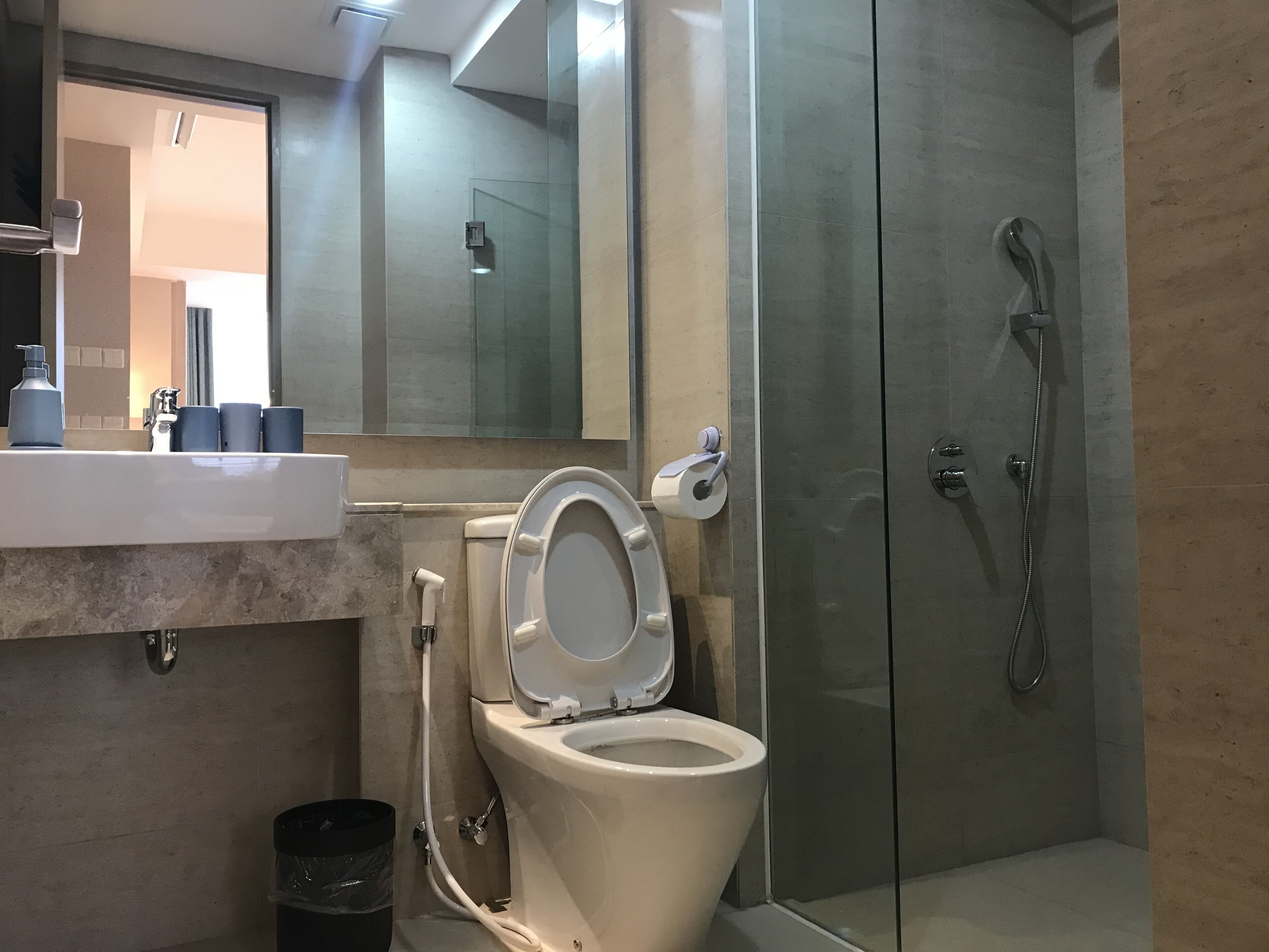 A modern bathroom with a toilet, sink, and glass-enclosed shower.