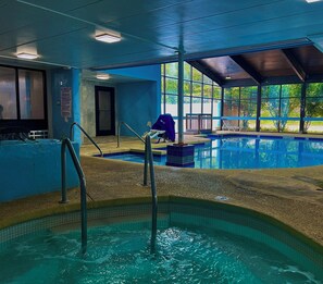 An indoor swimming pool with clear water, a lifeguard chair, and a pool rule sign. - Pine Lake Resort and Banquets (La Porte)