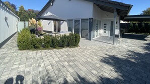 A modern house with a covered patio, a garage, and a paved driveway. - TLA Modern and cozy holiday house freestanding (Waldmohr)