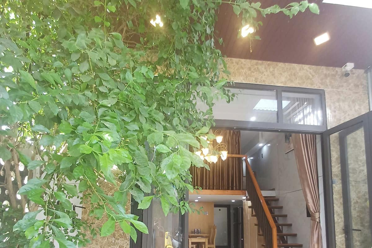 A dining area with a table and chairs, a staircase, and a glass door leading to another room.
