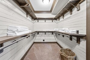 A clean, well-lit public restroom with white wooden walls, metal towel racks, and a central drain. - Beautiful Monteagle Bluff Mountain Home Sleeps 12 (Monteagle)