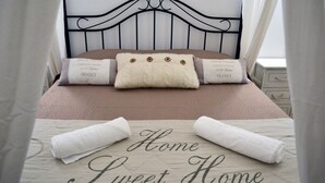 A neatly made bed with a headboard, pillows, and a blanket. The bedspread has the text "Home Sweet Home" printed on it. - Dimora Castelli (Palermo)