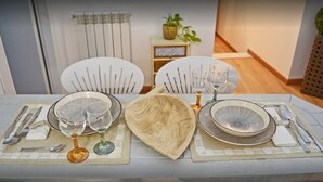 A dining table set with plates, glasses, and cutlery, surrounded by chairs. - Dimora Castelli (Palermo)