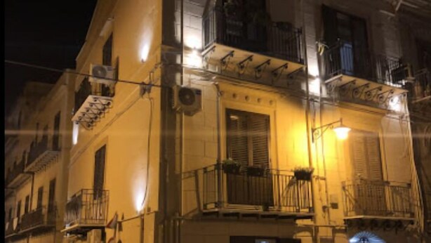 A multi-story building with balconies, a staircase, and a ground-level entrance. - Dimora Castelli (Palermo)