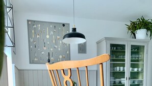 A wooden rocking chair with a cushion, a wooden bench, and a dining table with chairs. - Frauenstein station CASTLE VIEW (Frauenstein)