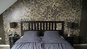 A bedroom with a bed, two bedside tables, and a wall with a mechanical gear pattern. - Frauenstein station CASTLE VIEW (Frauenstein)