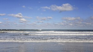 Une plage avec des vagues et un ciel dégagé.