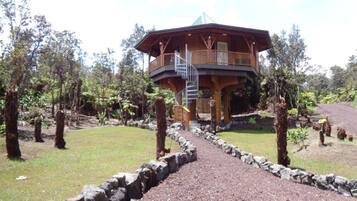 Surrounded by nature, this cabin-style building features a central tower and a balcony.