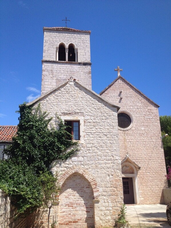 A stone church with a bell tower and arched entrance.