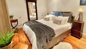A bedroom with a bed, bedside tables, a mirror, a dresser, and a potted plant. - Flat in the most desirable location in London - Kensington (London)