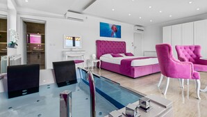 A modern hotel room with a large bed, a small desk, a chair, a pool, and a bathroom. - Villa Anela with pool in Porec, Istria (Buici)