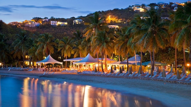 A beachside resort with multiple white tents and umbrellas, palm trees, and a calm sea. - Family Friendly 3BR Villa in Paradise- Saturday March 26- Sat., April 4, 2026 (St. John)